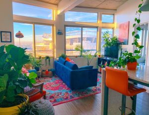 a blue sofa and an orange chair inside a modern apartment for a maximalist approach