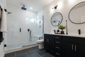 Bathroom with Black Cabinets, Round Mirrors and Glass Shower Cabin 