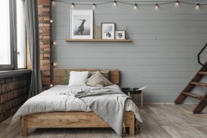 a bedroom with grey walls and grey wooden floor