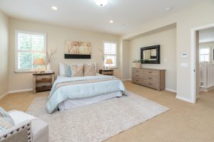 Big bedroom with bed, pillows, rugs and furniture